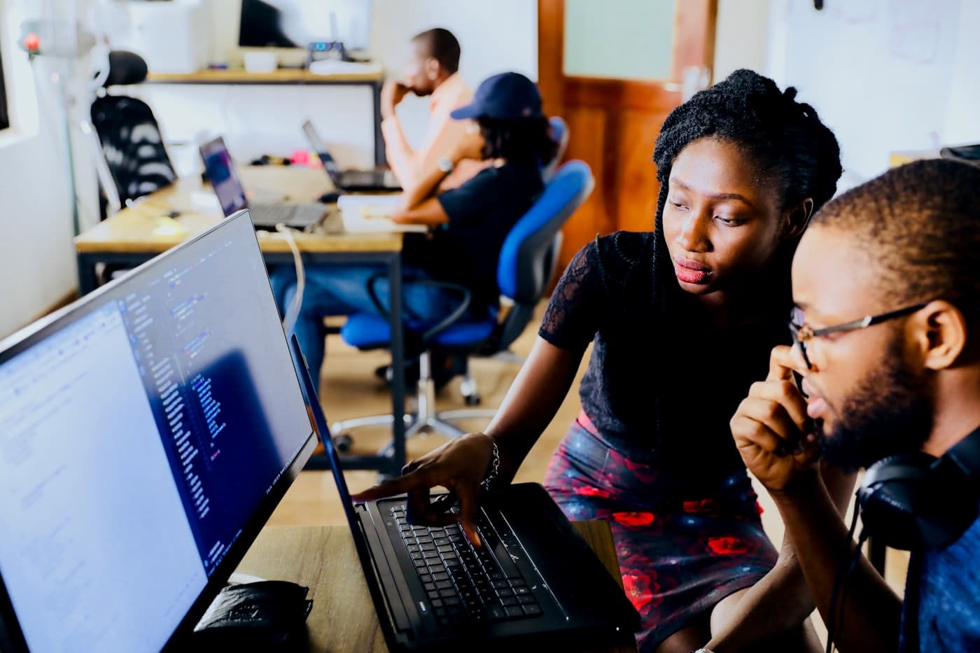 Two entrepreneurs working through a plan together at a laptop