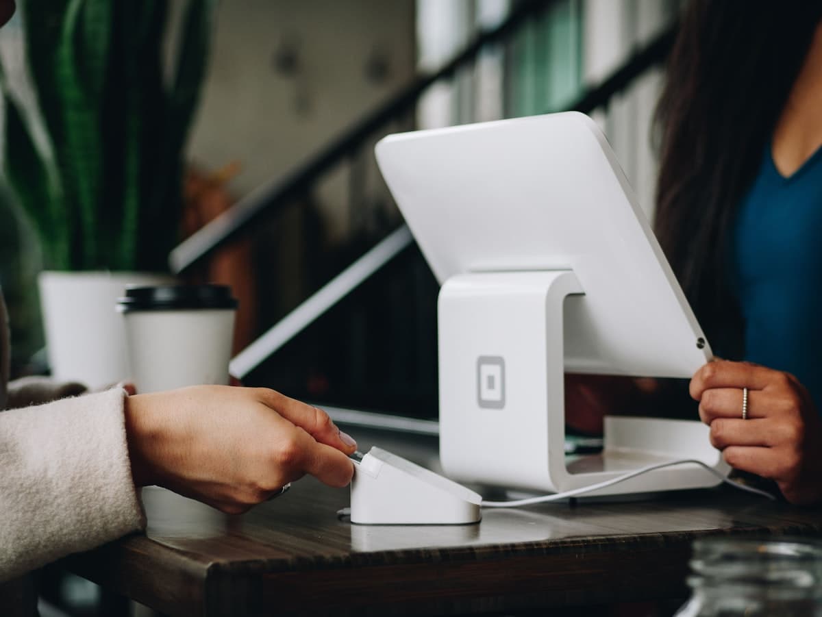 A small business owner taking a payment on a point-of-sale terminal
